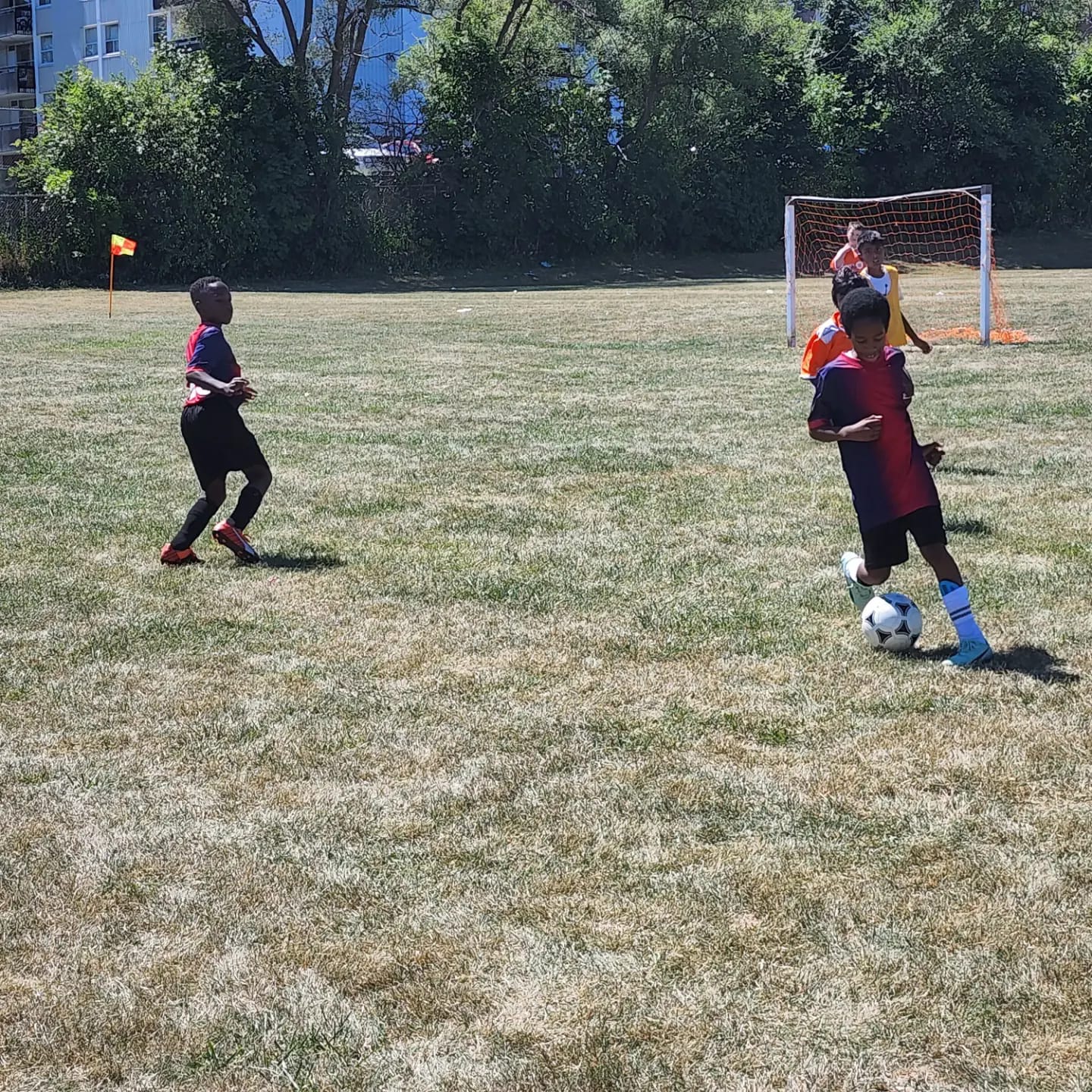 Youth soccer players in the Development Group training on an outdoor field with coach supervision