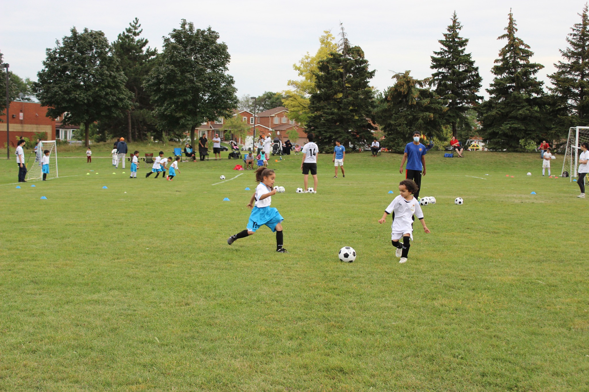 Two girls playing soccer outdoors Super Girls program participants training