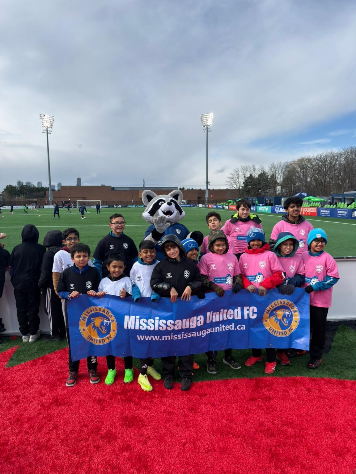 Mississauga United FC youth players with the club banner at an Inter Toronto match