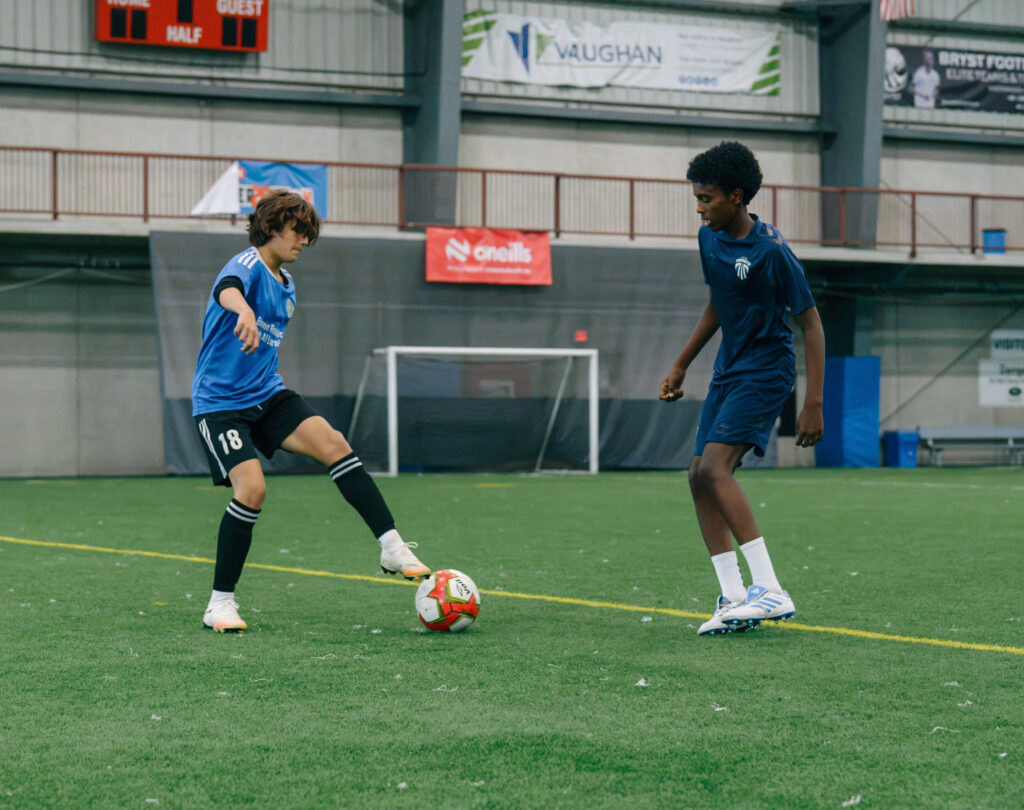 Mississauga United player trains with an Inter Toronto player during a joint soccer development session.