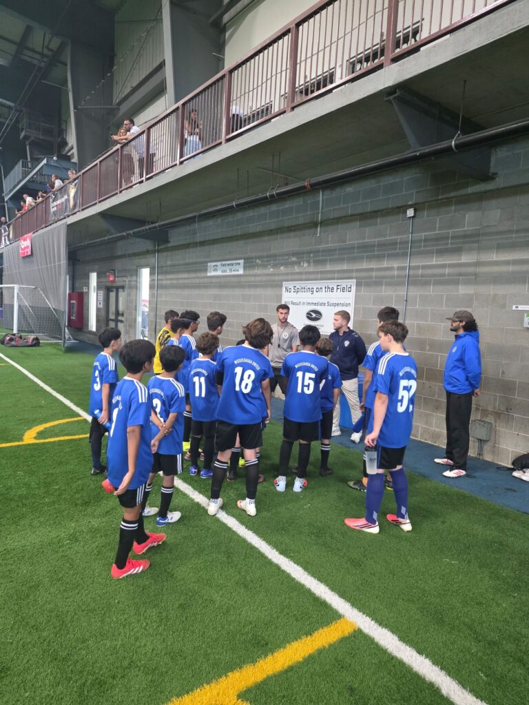 Mississauga United players listen to coaches during a joint training session with Inter Toronto.