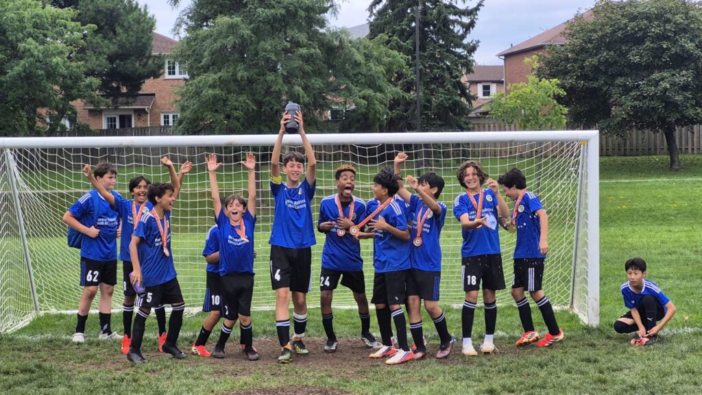 Mississauga United FC U12 players celebrating their championship with medals.